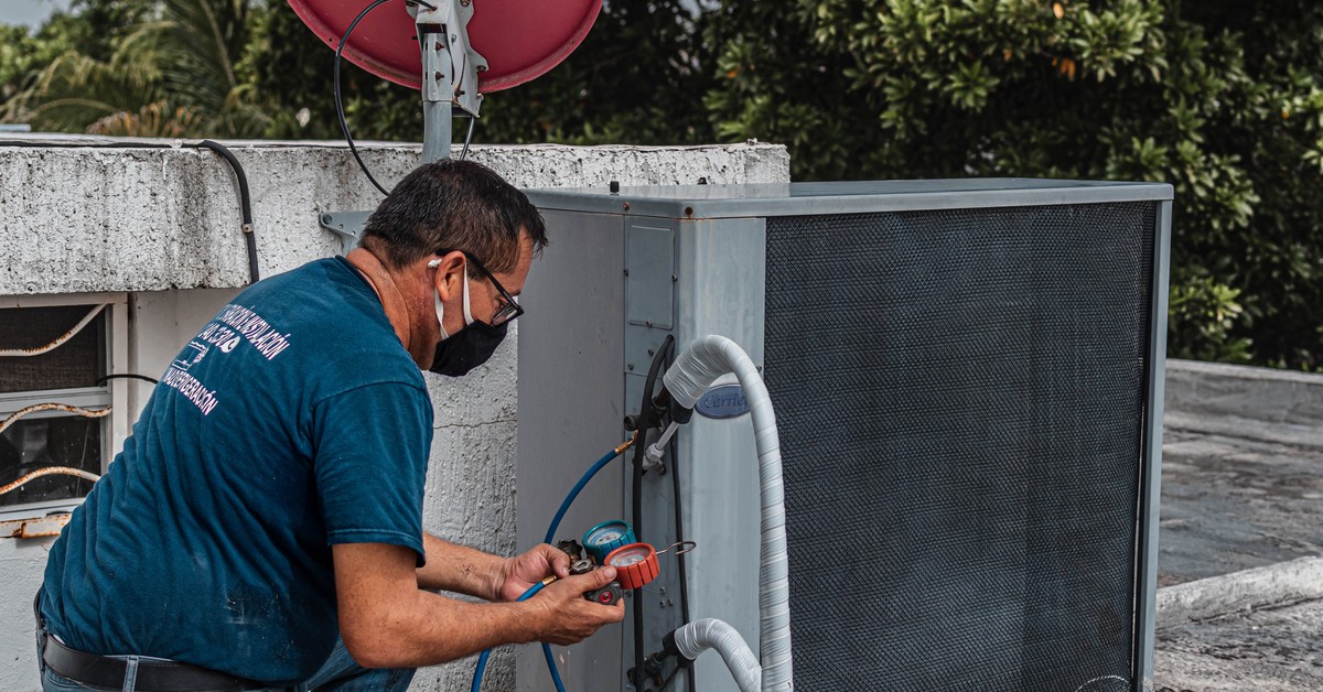Licensed HVAC technician servicing an outdoor AC unit in Tampa